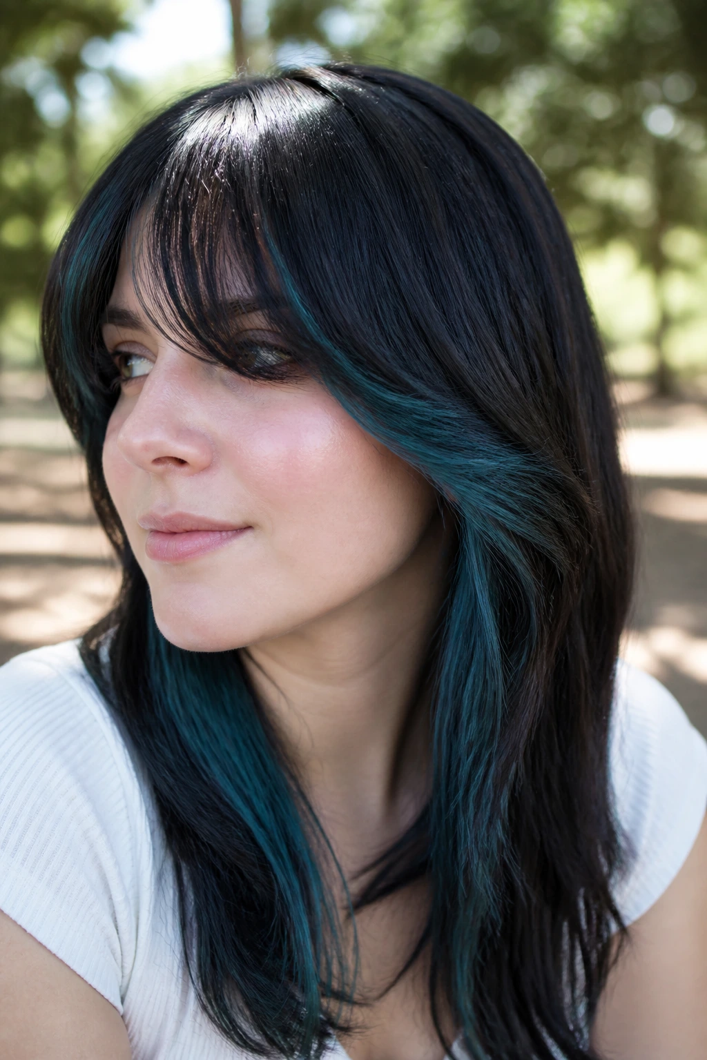 Close-up of a real woman with denim-teal hidden panels and long bangs outdoors
