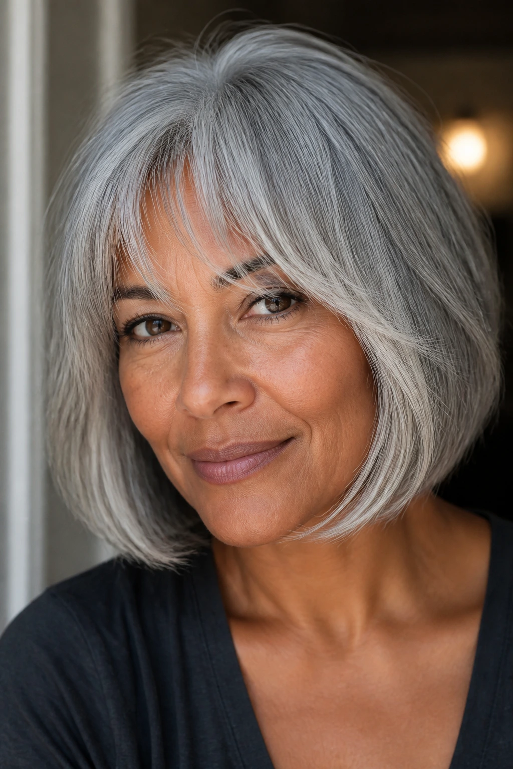 Close-up portrait of a real woman with a dove gray bob and feathered bangs