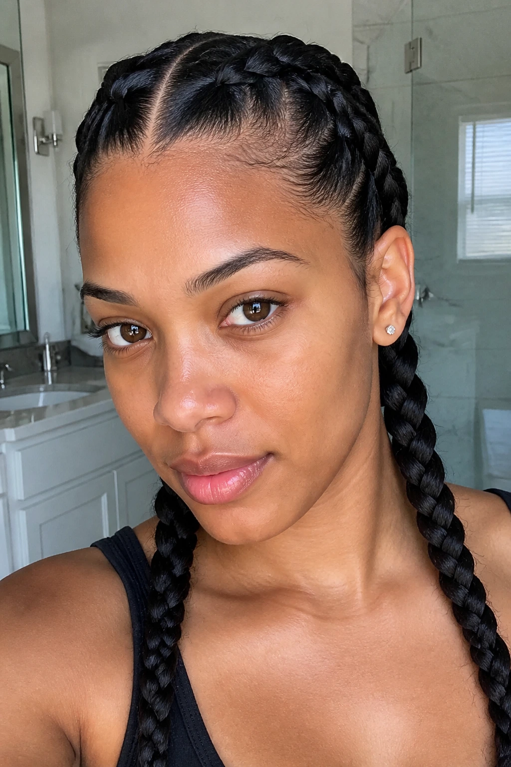 Close-up of a real woman with Dutch braid pigtails in a bright bathroom