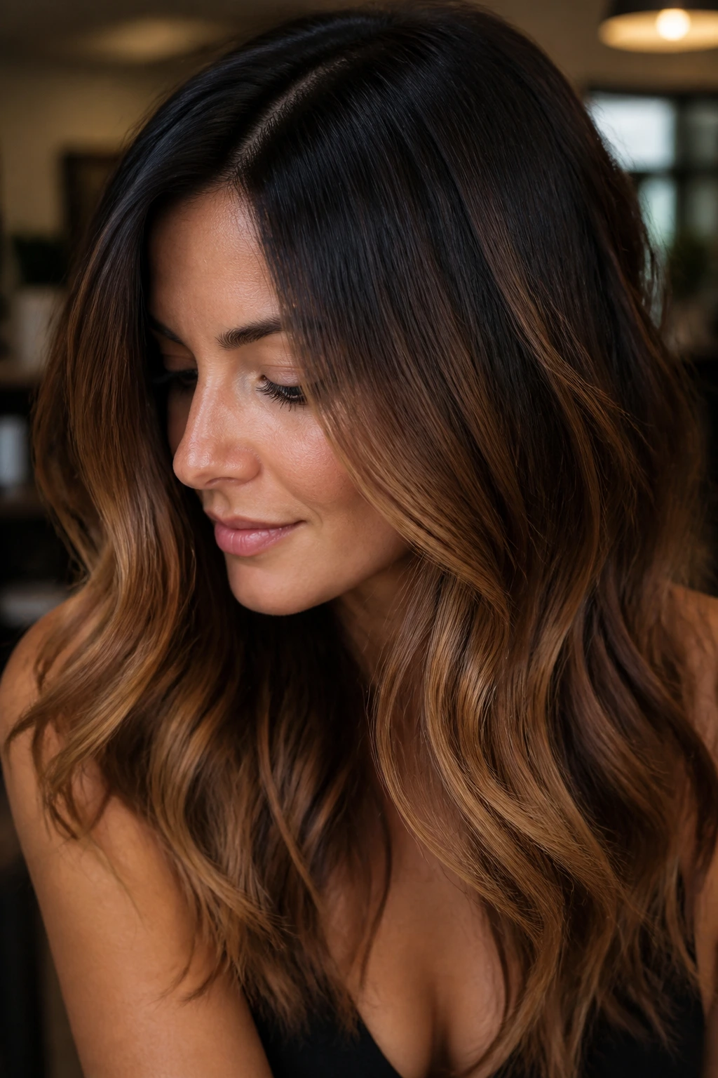 Portrait of a woman with espresso roots blending into caramel lengths
