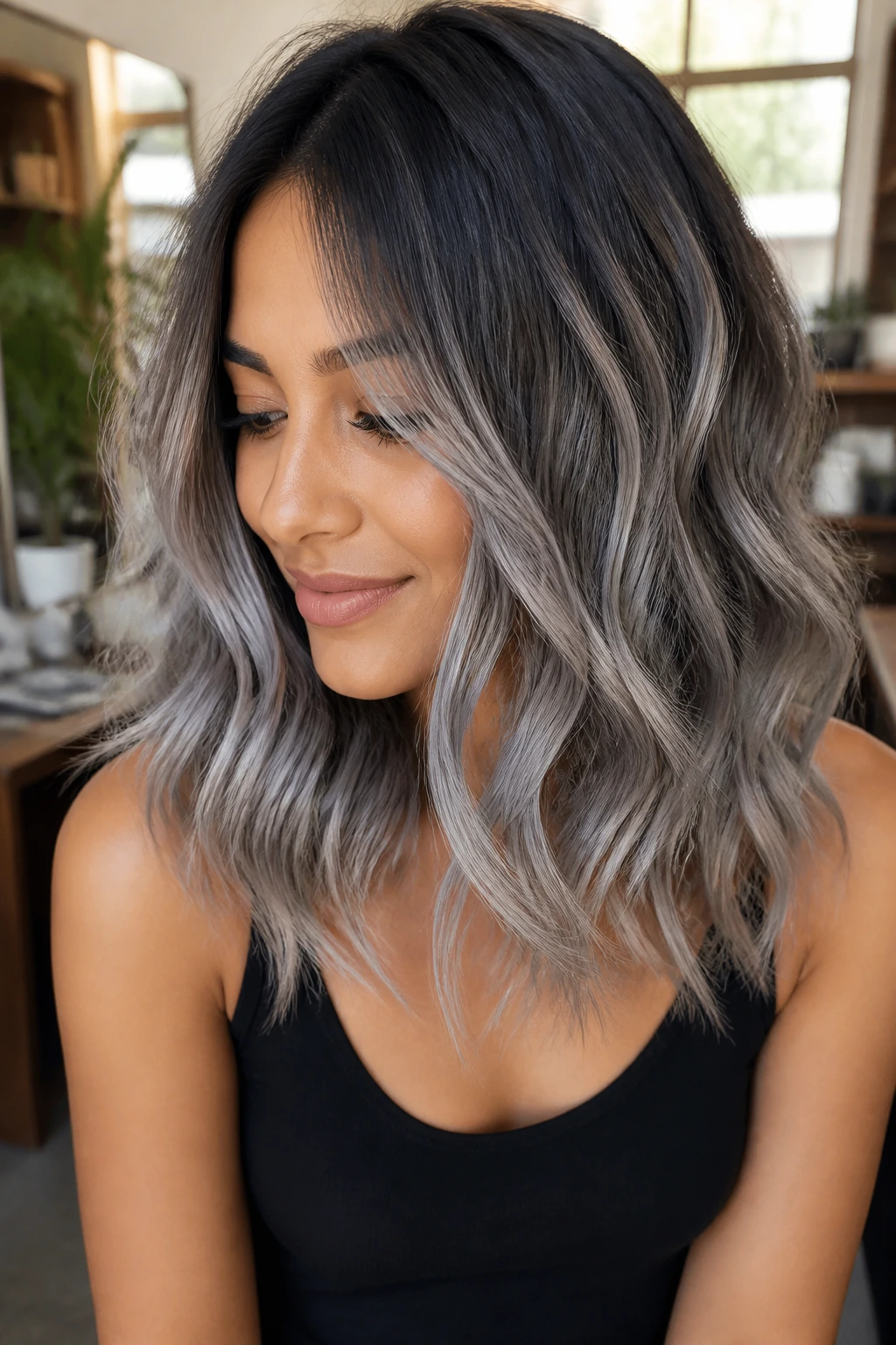 Portrait of a person with espresso roots and silver balayage waves on tan skin.