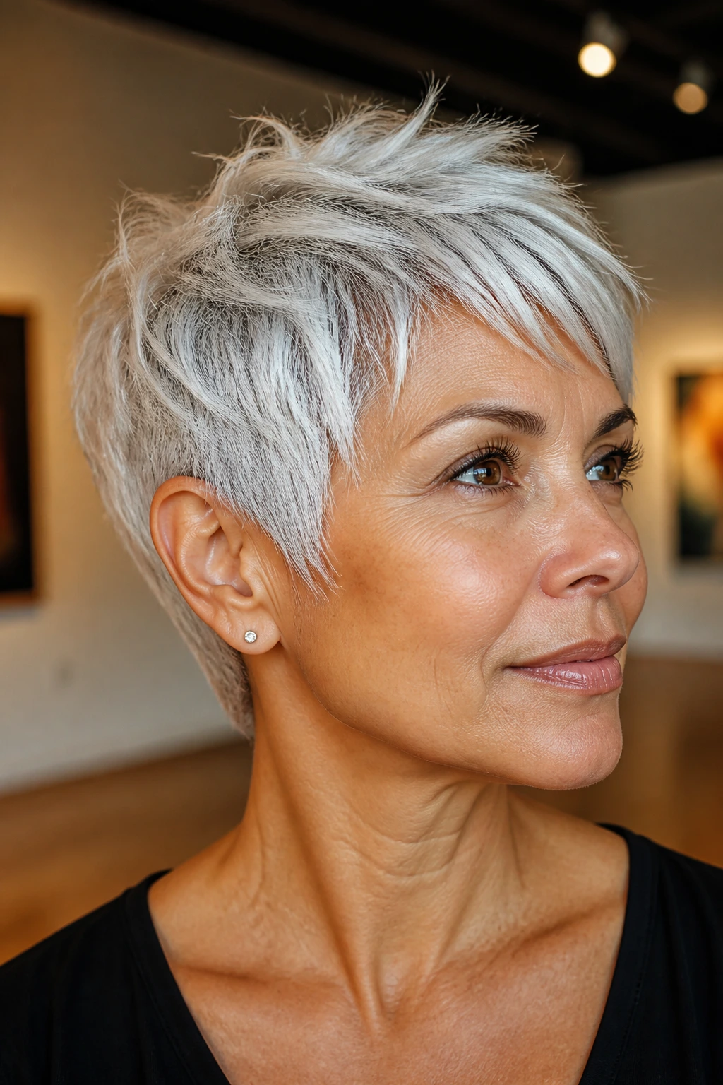 Close-up of a real woman with feathered pixie in white-silver and frosted edges.