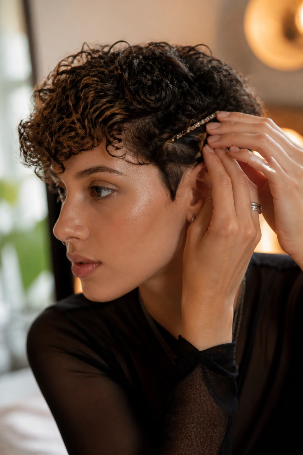Close-up of person adjusting finishing clip to refine curls