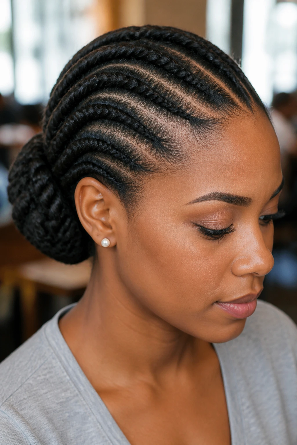 Real person with flat twists swept to the side into a rolled bun behind the ear