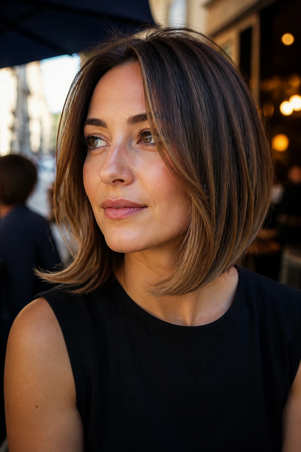 Close-up of a real woman with a flipped-end inverted lob in cafe-window light