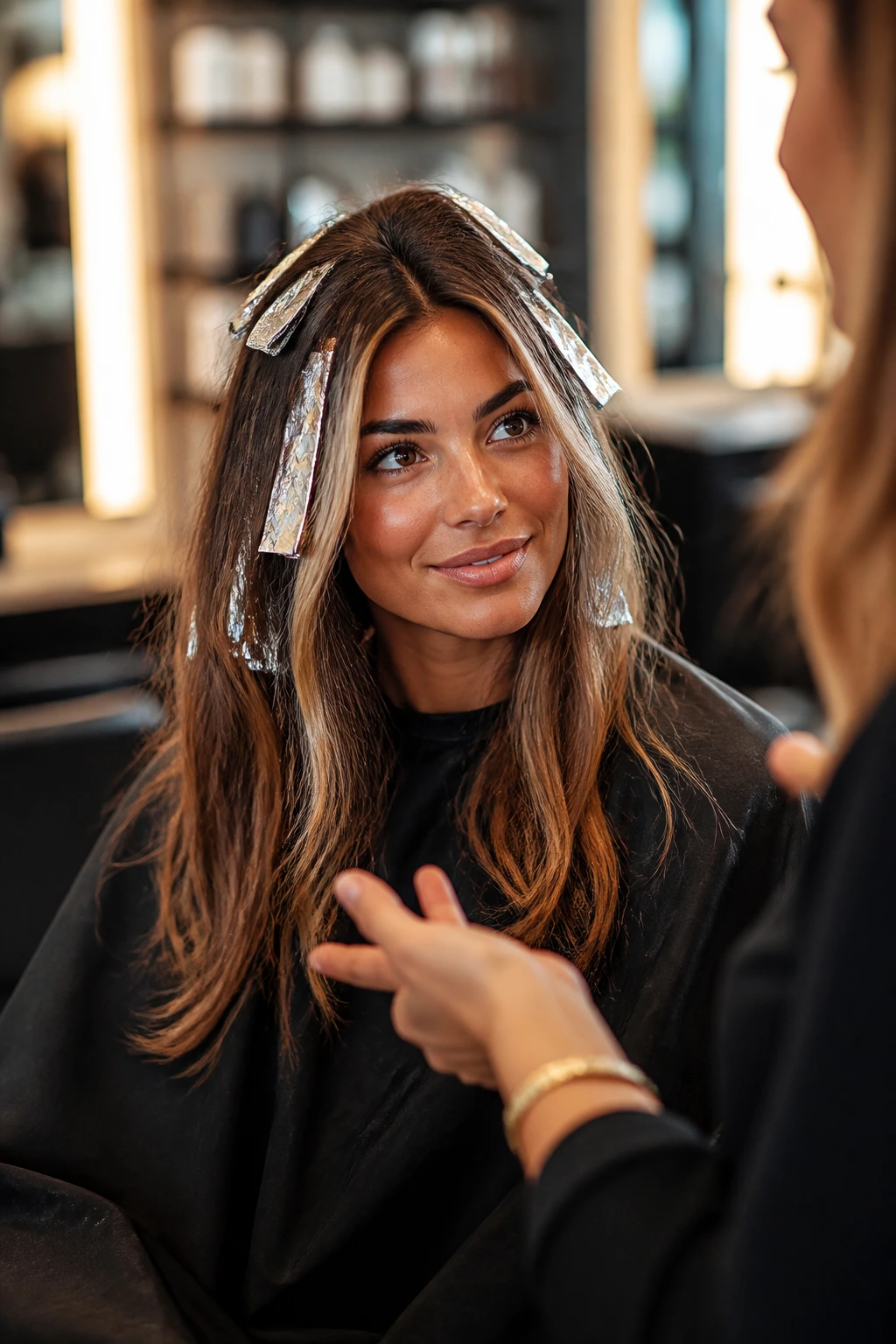 Real client in salon chair with foils in hair, in consultation with colorist