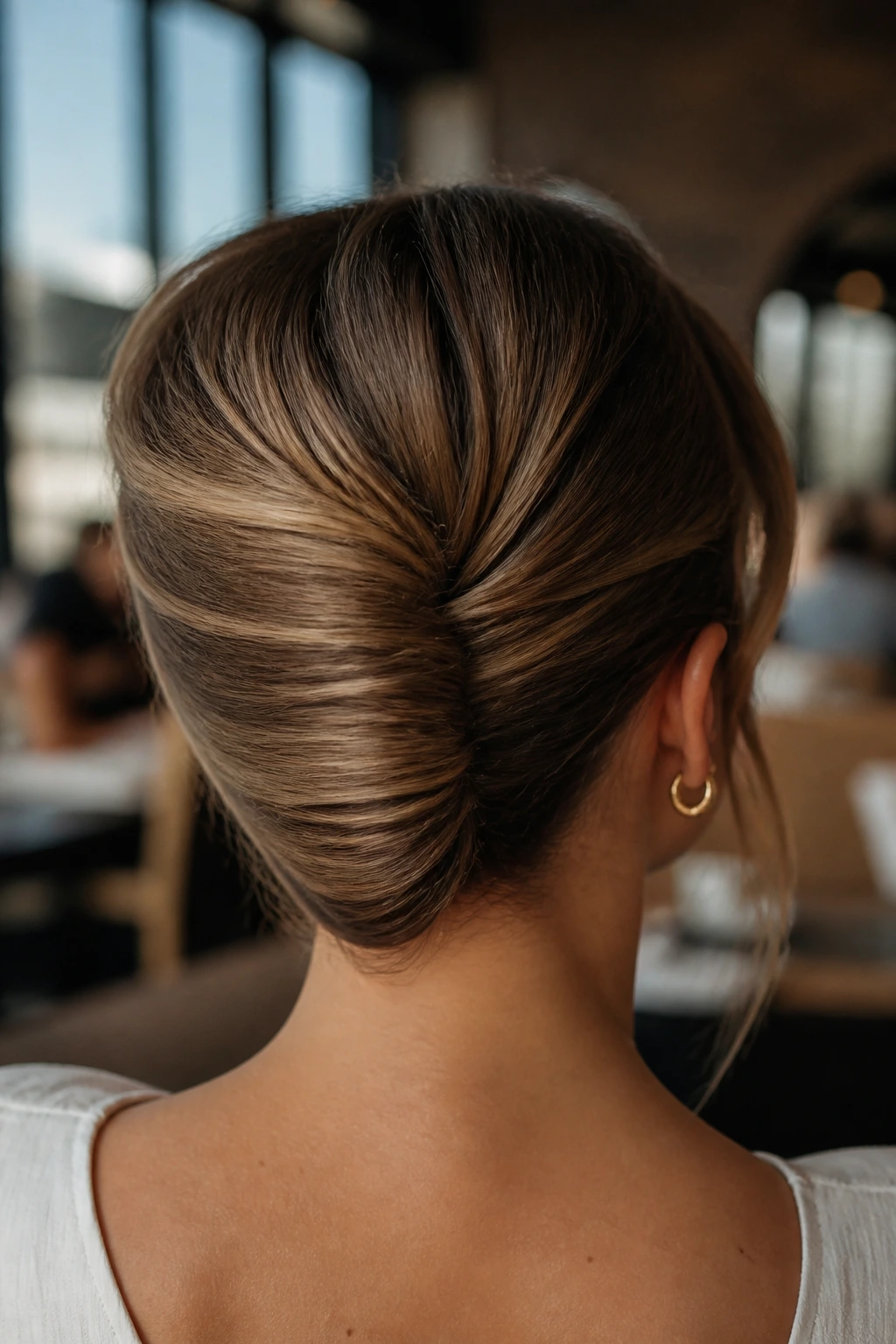 Back view of a woman with a French roll-inspired tuck at the nape