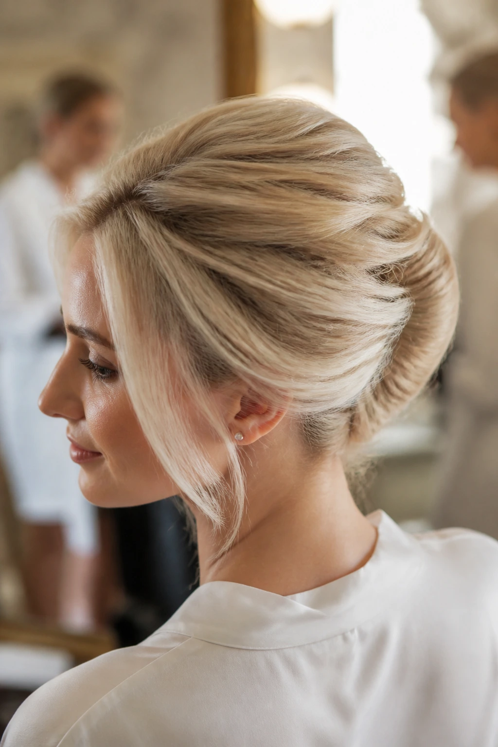 Close-up of a real woman's head showing a French twist with beige blonde hair