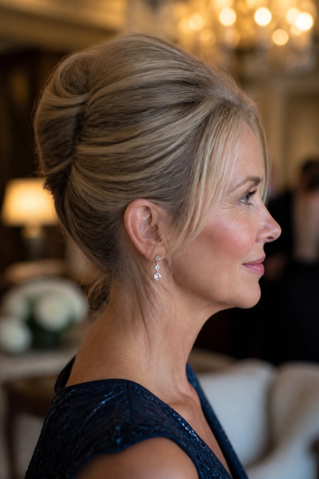 Close-up side profile of a real woman with a sleek French twist and crown lift.