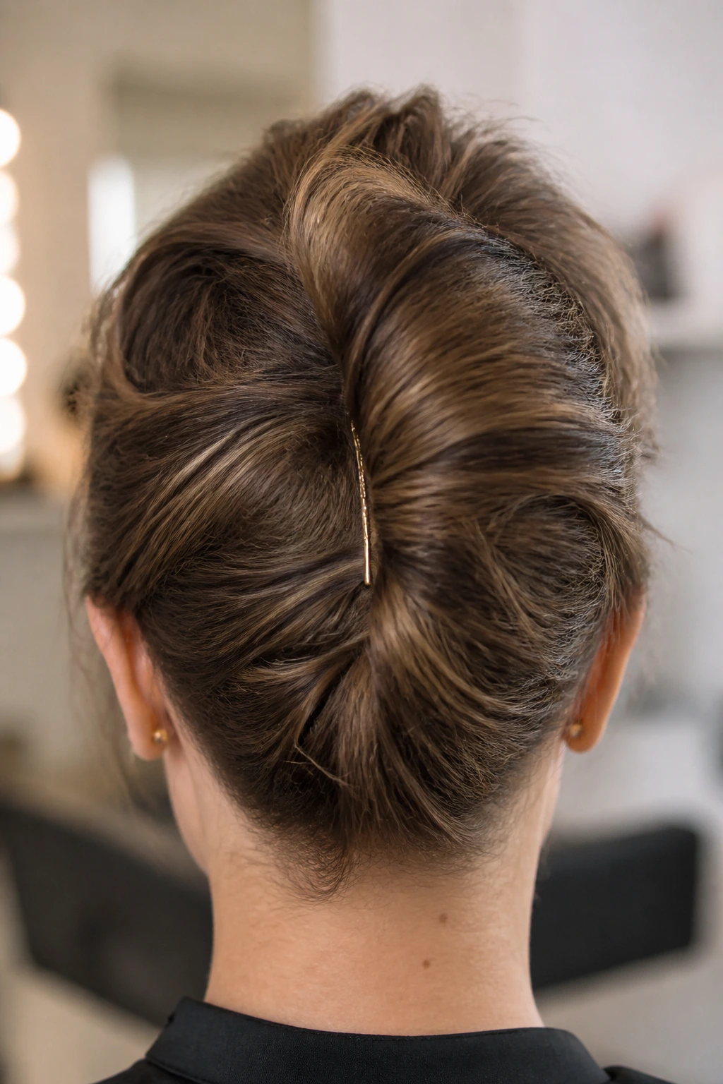 Back view of head with a French Twist showing slips and bulges due to common mistakes.