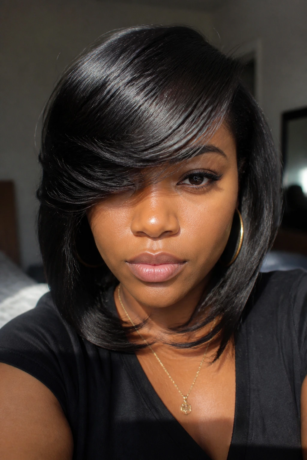 Close-up of a Black woman with front-sweep bangs filling the frame.