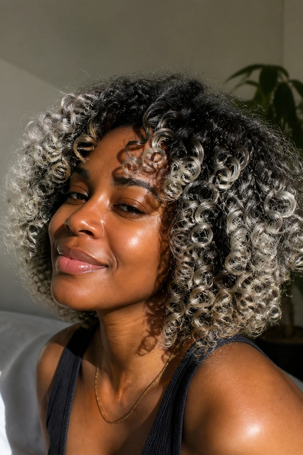 Close-up of a real person with curly frosted-platinum ends on deep skin