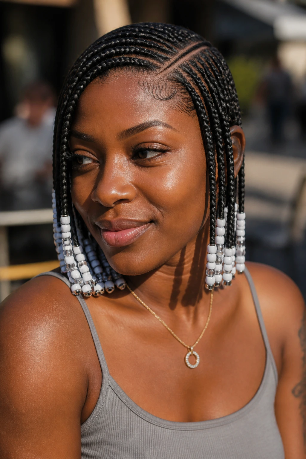 Close-up of a real person with side-part Fulani braids and beaded tips.