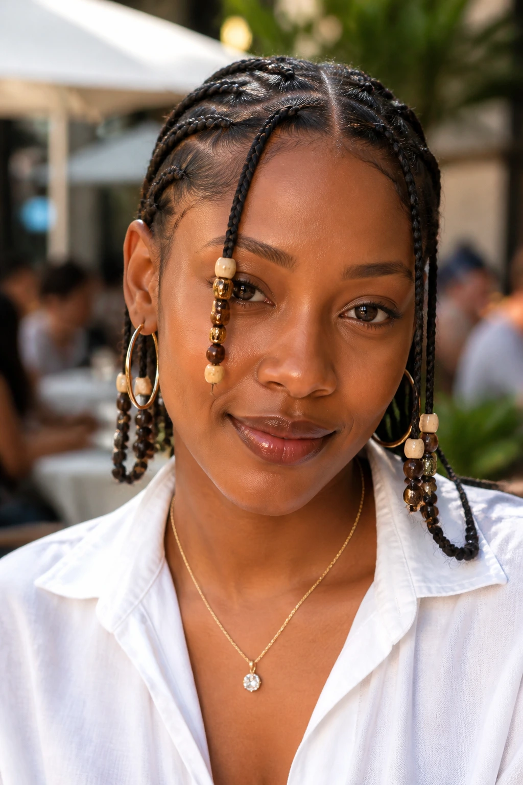 Close-up portrait of a real person wearing Fulani-inspired knotless braids with front beads