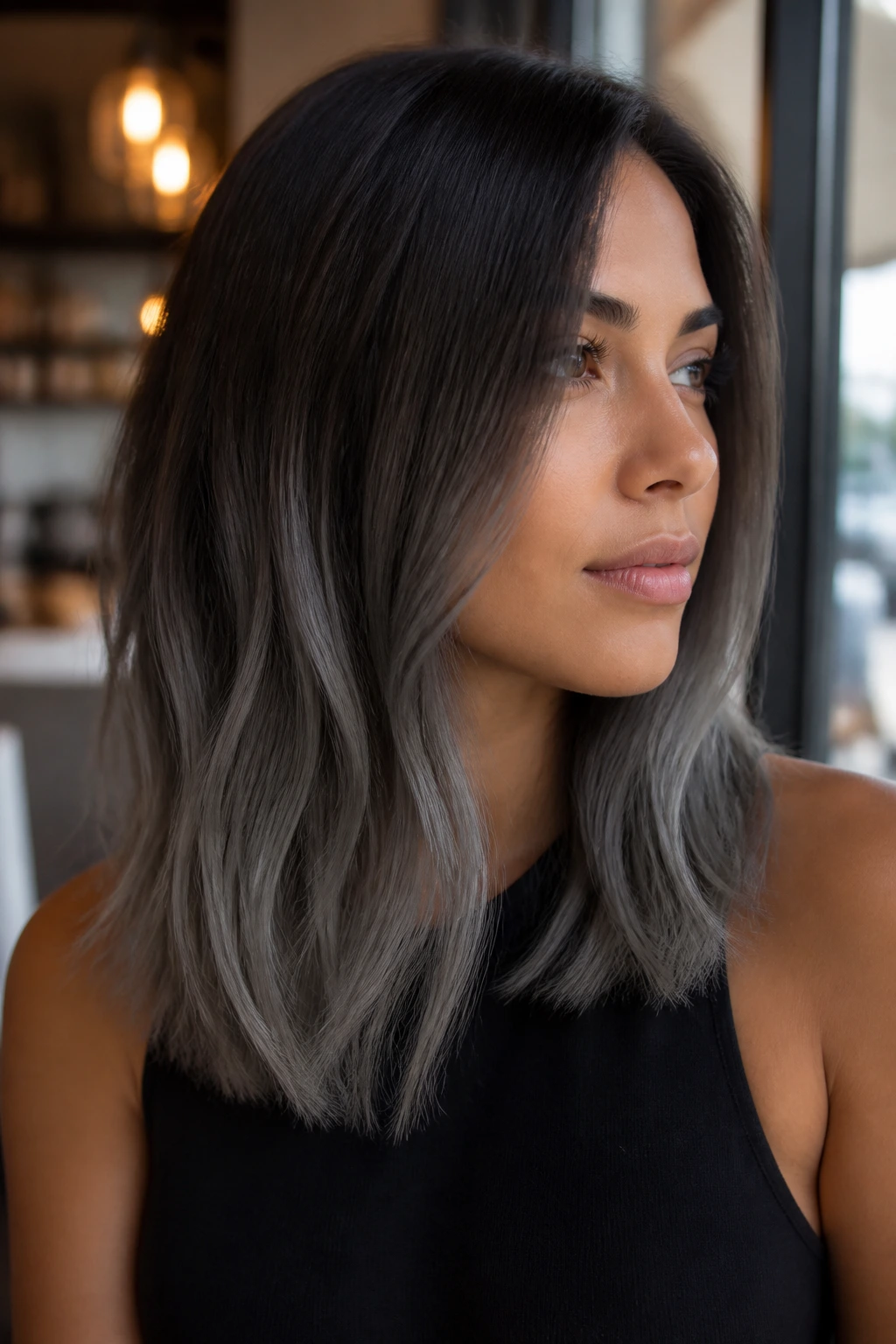 Graphite ombre on a sleek mid-length cut on a tan-skinned model.