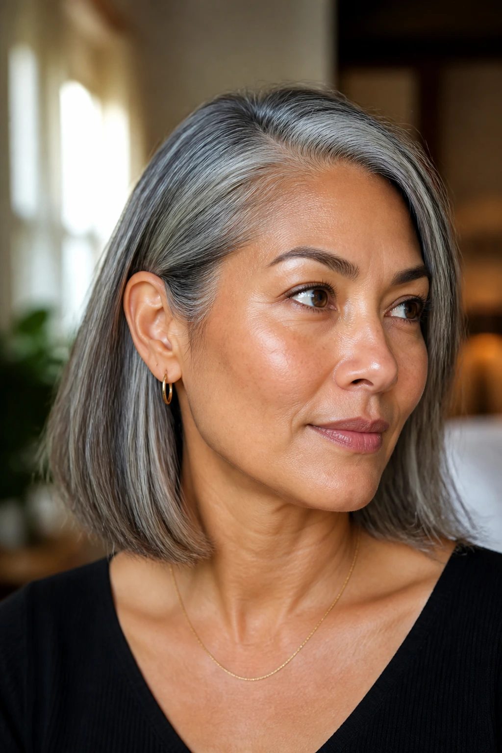 Close-up of a real woman with a tucked-behind-the-ear lob and exposed jawline in warm light