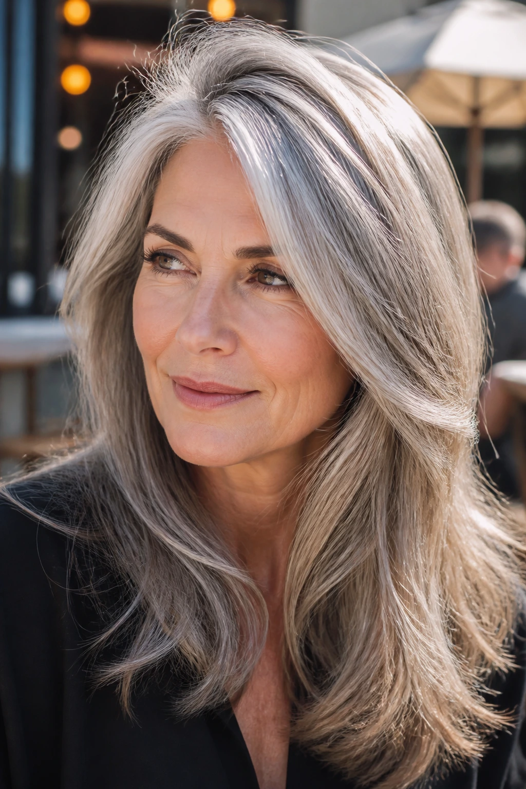 Portrait of a person with glossy gray hair showing lift at the crown in outdoor light