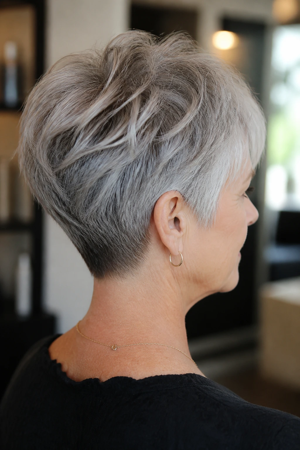 Gray-haired woman with stacked nape pixie and airy layers