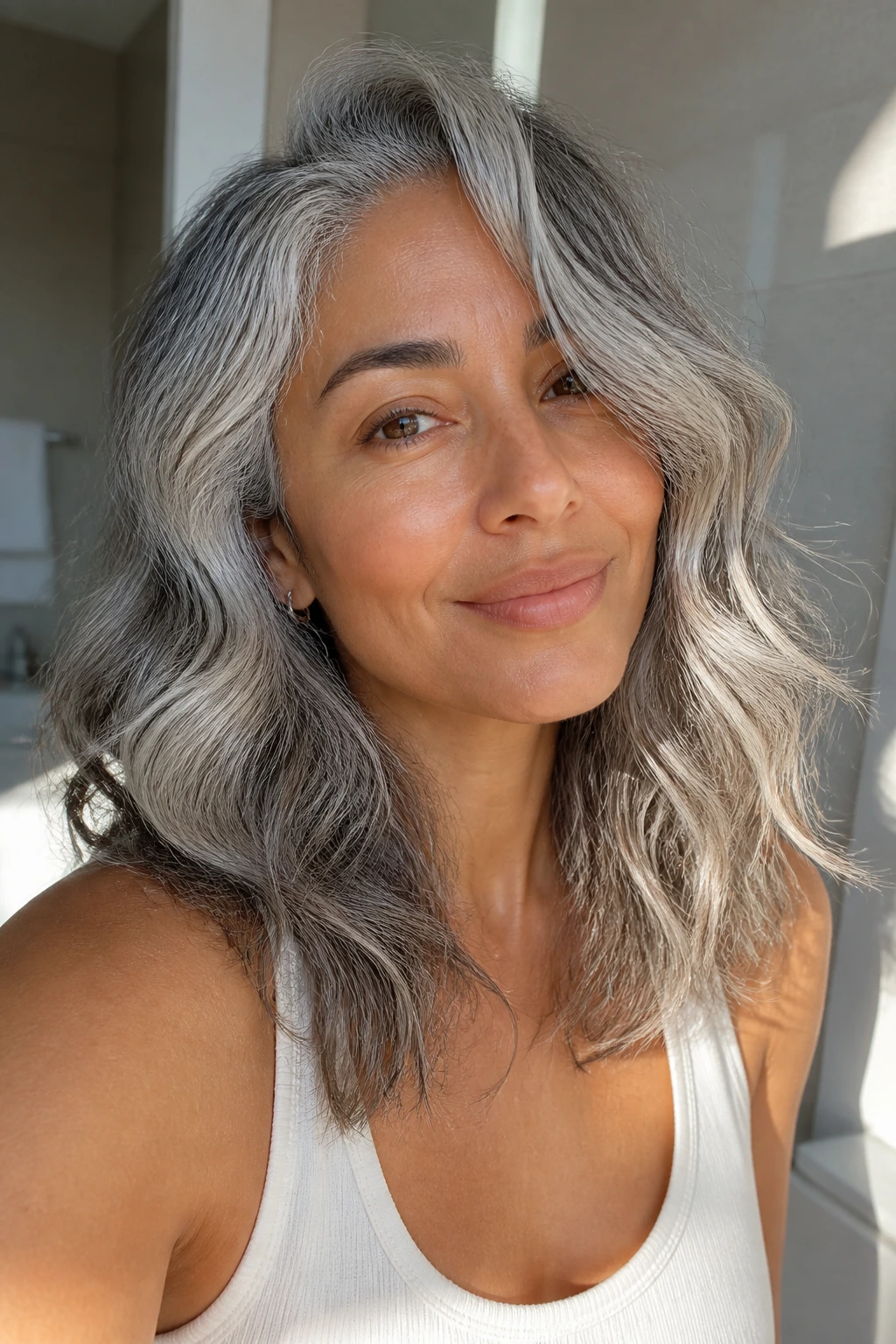 Portrait of a person with cool silver-gray hair in soft bathroom light