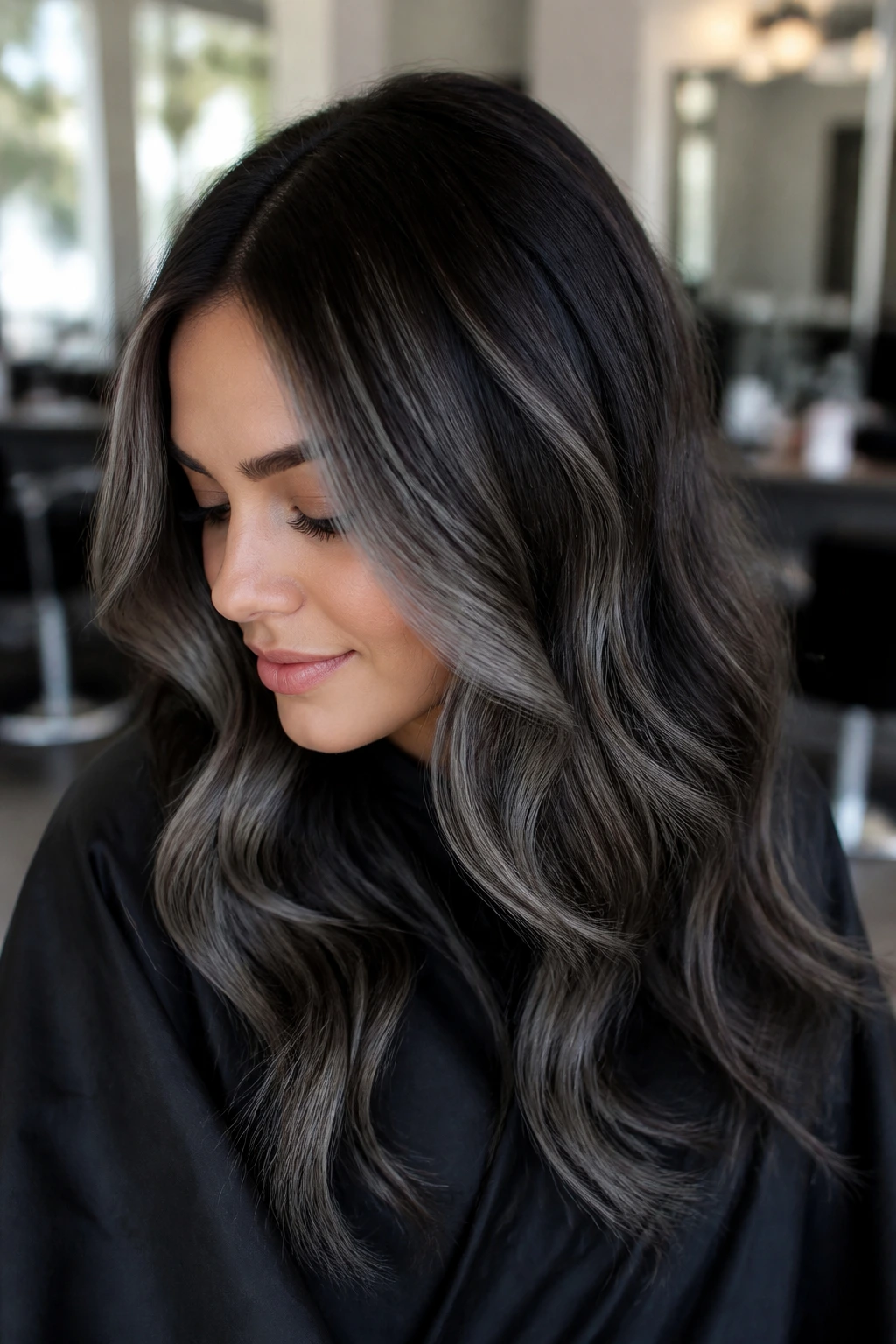 Portrait of a woman with cool grey ribbons in brown balayage in a salon
