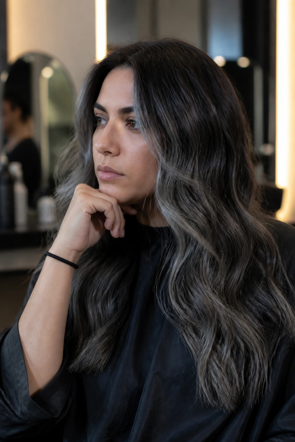 Close-up portrait of a person in a salon chair with cool grey balayage