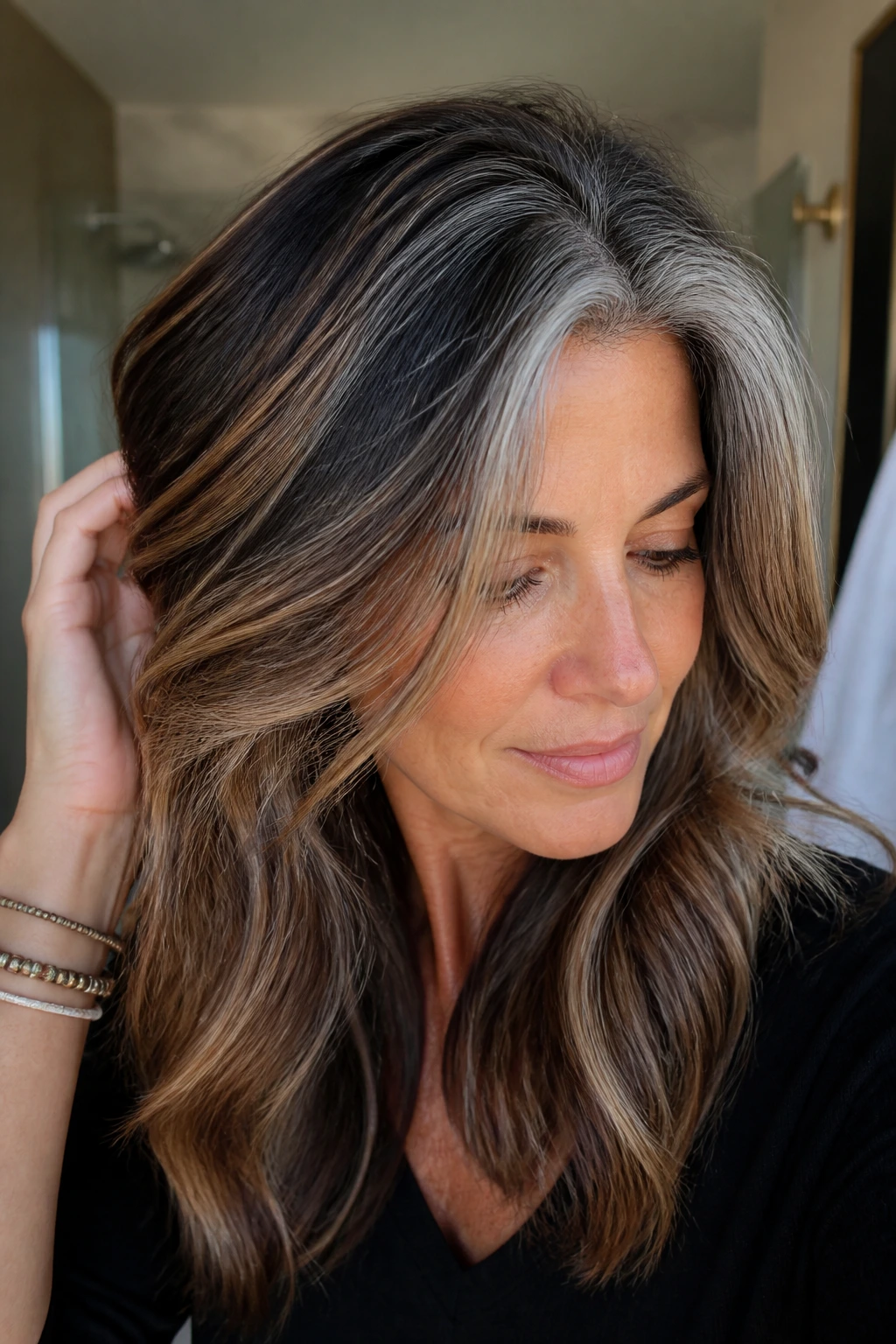 Close-up of hair with grey, caramel, and dark roots looking fresh in a bathroom