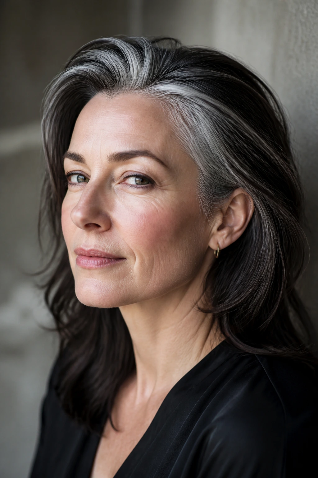 Close-up of a person with dark base hair and intentional silver at temples