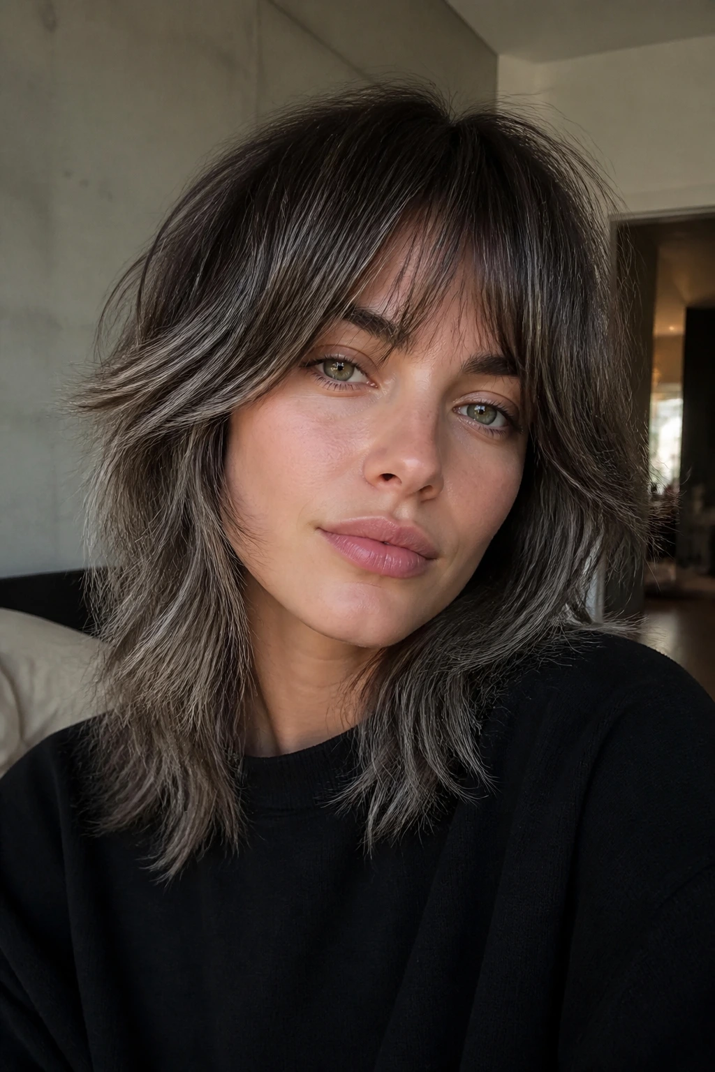 Portrait of a real person with grey mist balayage on a shag cut.