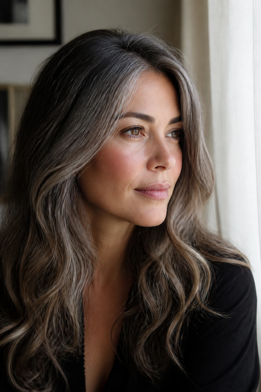 Close-up of brunette hair with grey tones and root melt on a real person.