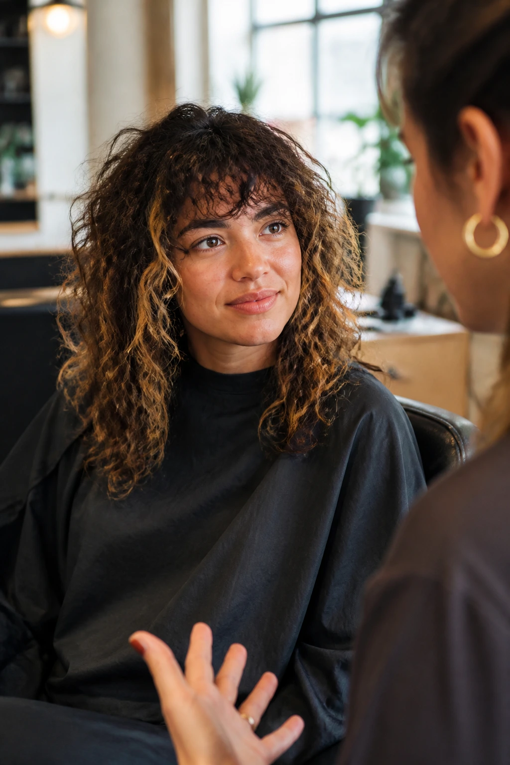 Real person in a salon chair discussing haircut details with a stylist