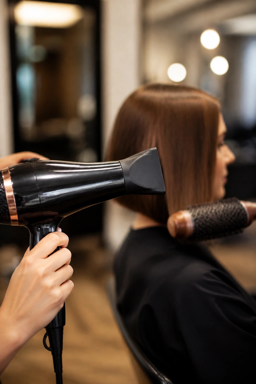 Close-up of a narrow-nozzle blow dryer used on hair in a salon