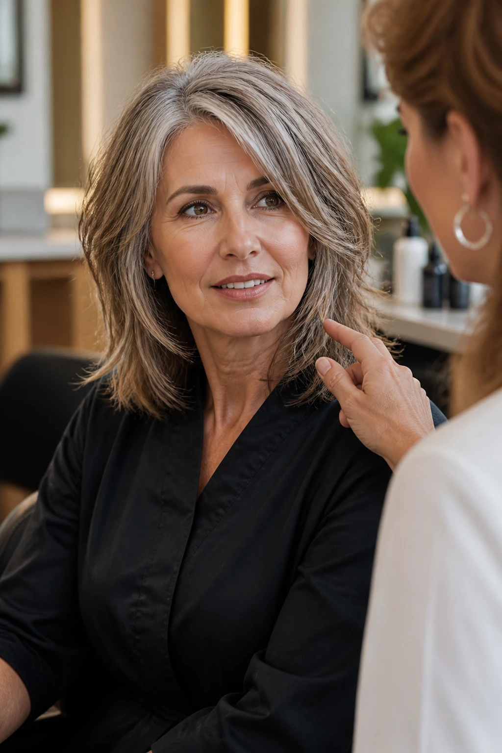 Real woman in a salon chair discussing a haircut for medium-length layers
