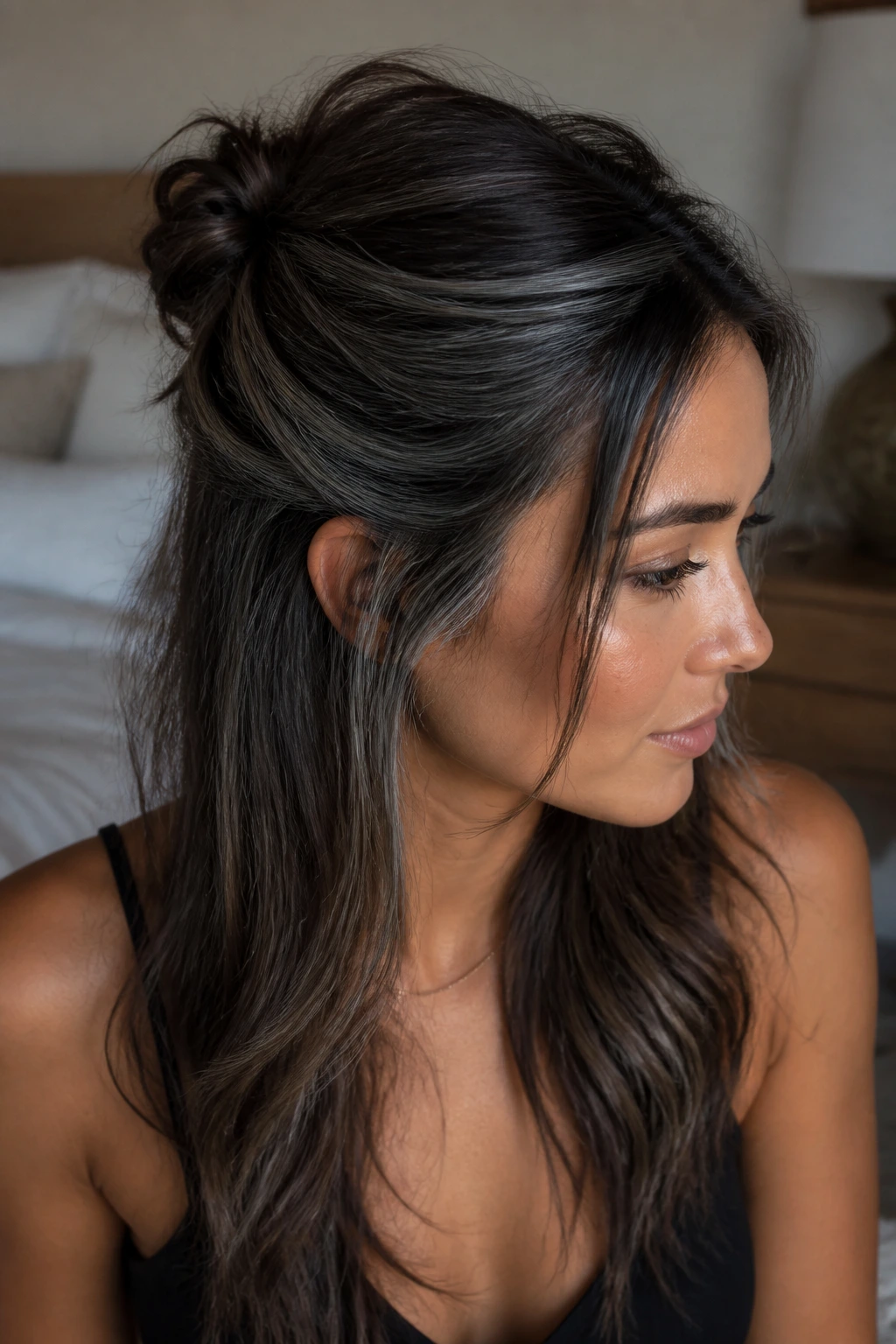 Close-up of a real person with a half-up hairstyle showing hidden grey lowlights on tan skin