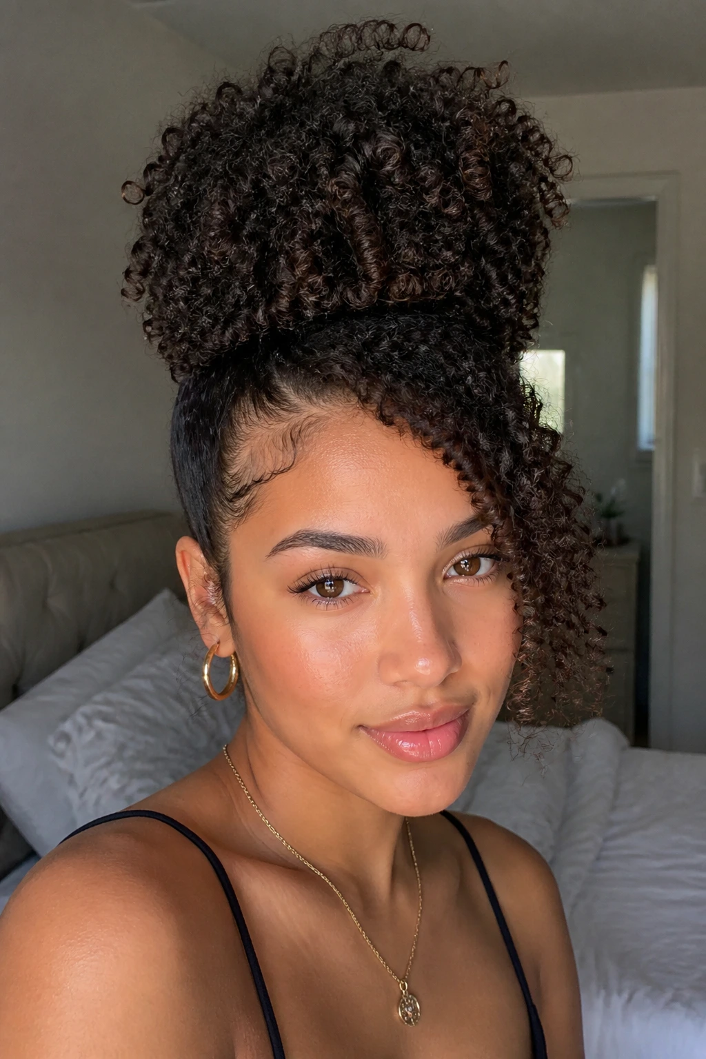 Biracial woman with high curly puff and deep side sweep