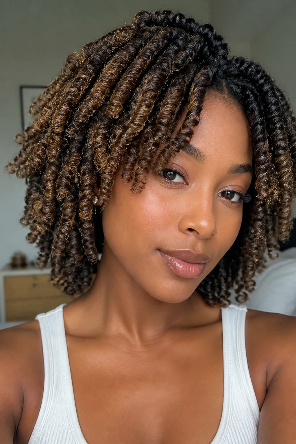 Close-up of a real person with honey babylights woven into a braid-out, soft indoor light.