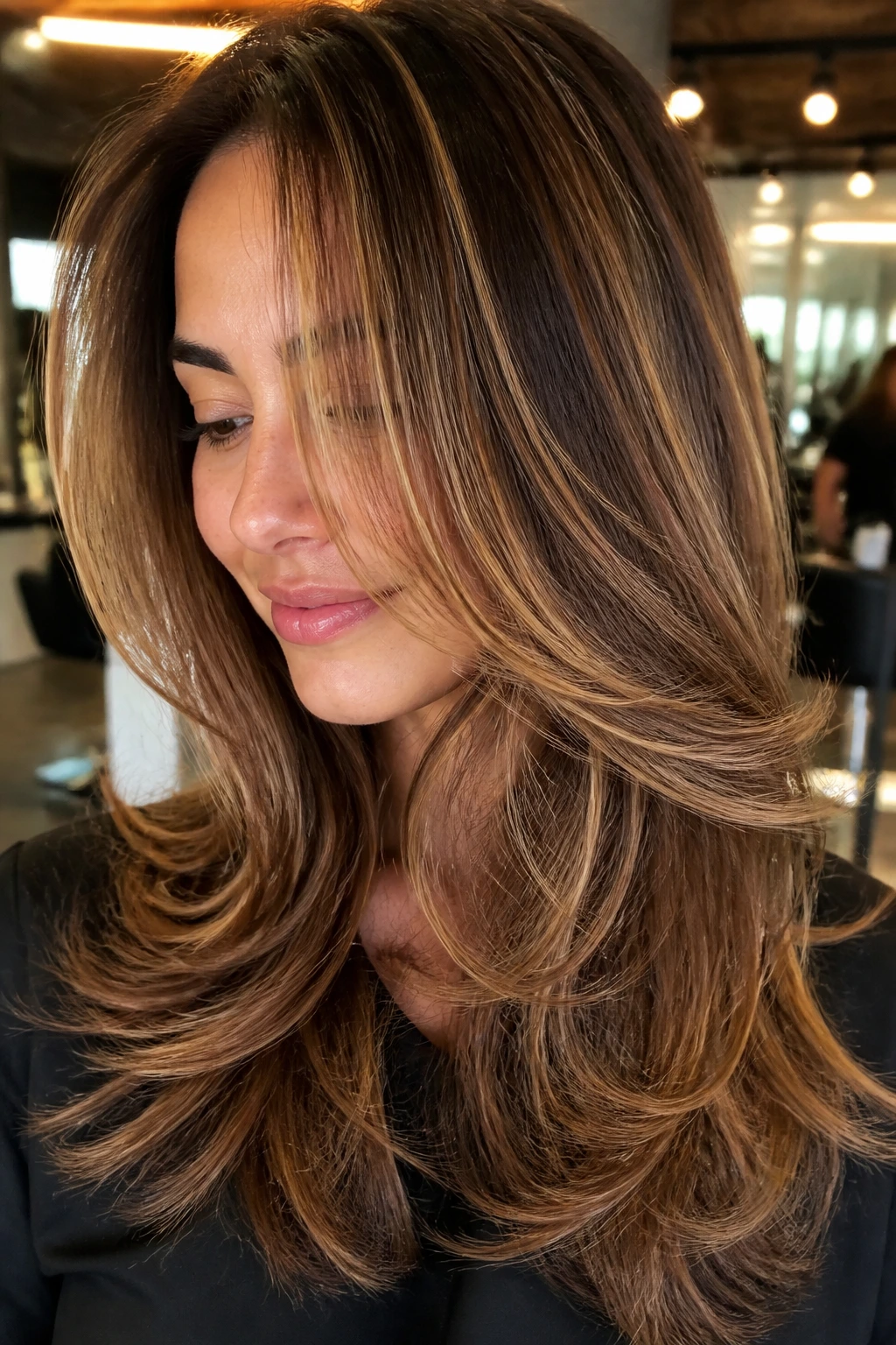 Brunette with honey caramel swirl on layered hair, close-up.