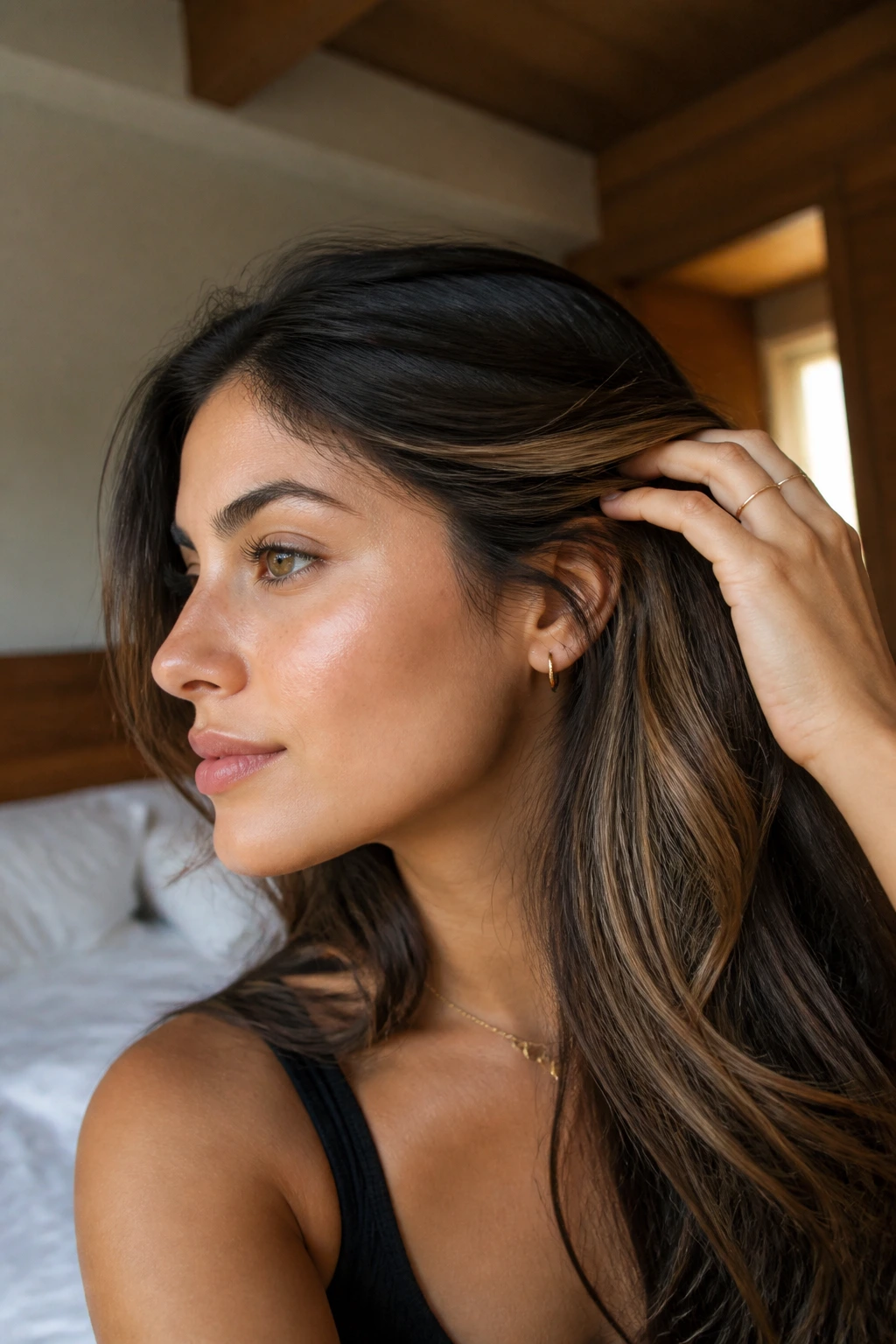Close-up of hair showing hidden honey panels beneath a darker top layer on olive skin.
