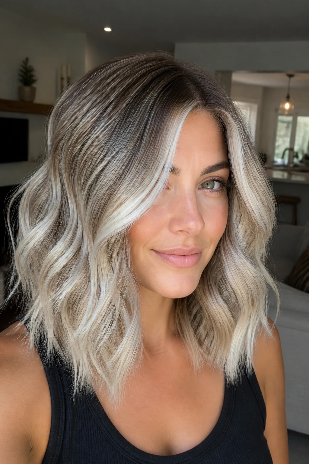 Close-up of a woman with rooted ice balayage waves and dark-to-light contrast