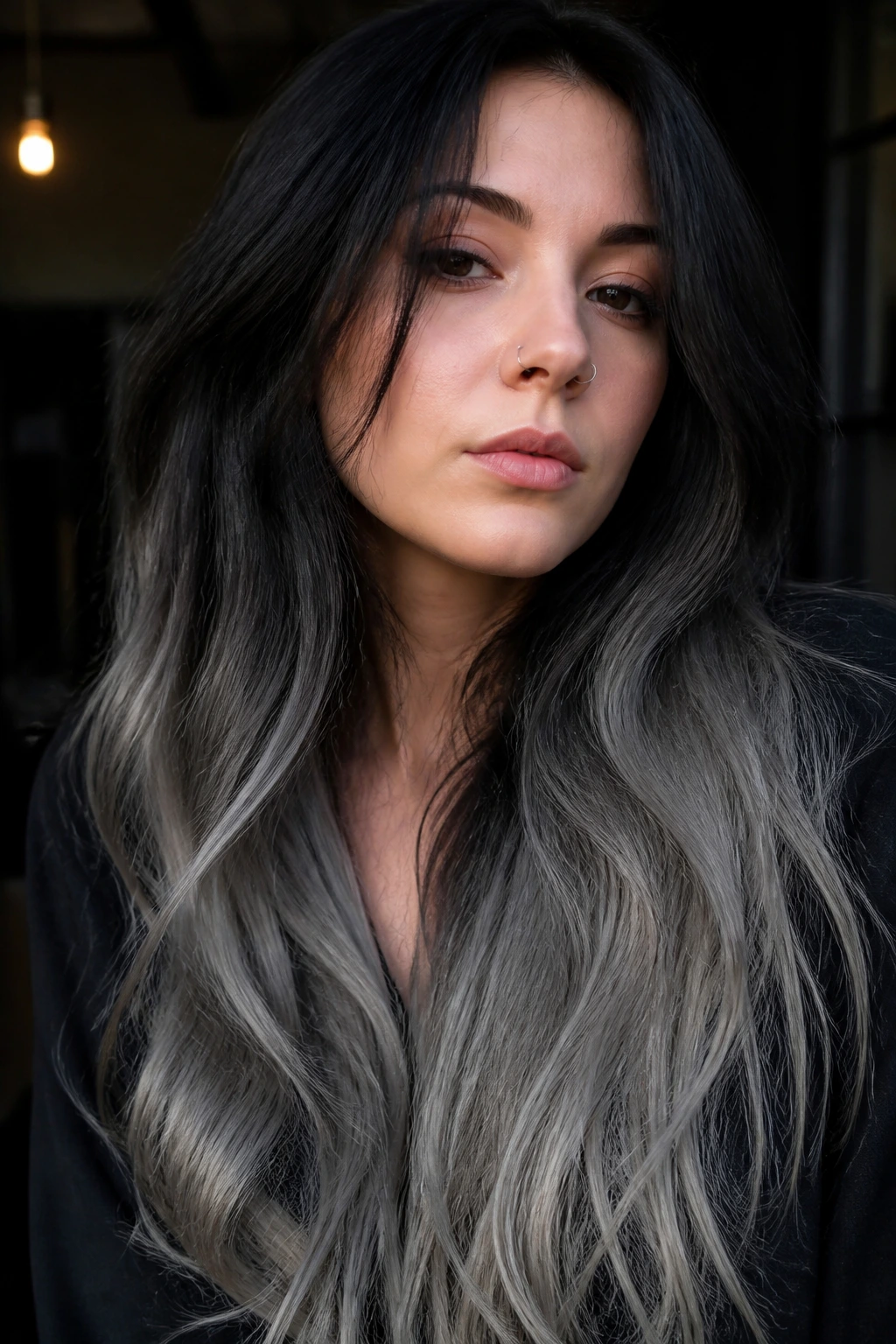 Portrait of a woman with dark roots and smoky inked grey ends on long hair