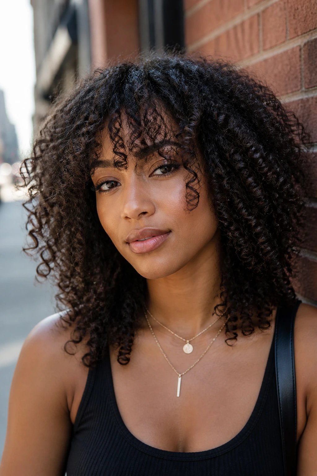 Close-up of a real person with invisible layers and airy fringe on an urban street backdrop
