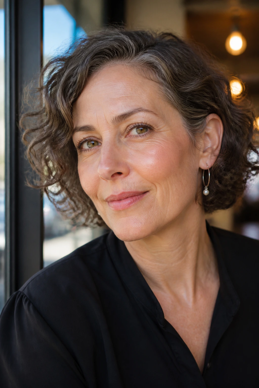 Close-up of a real woman with a jaw-length bob tucked behind the ear