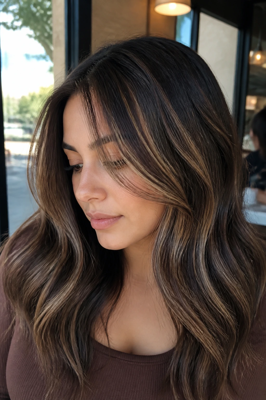 Close-up of a woman with latte swirl highlights in beige-brown tones