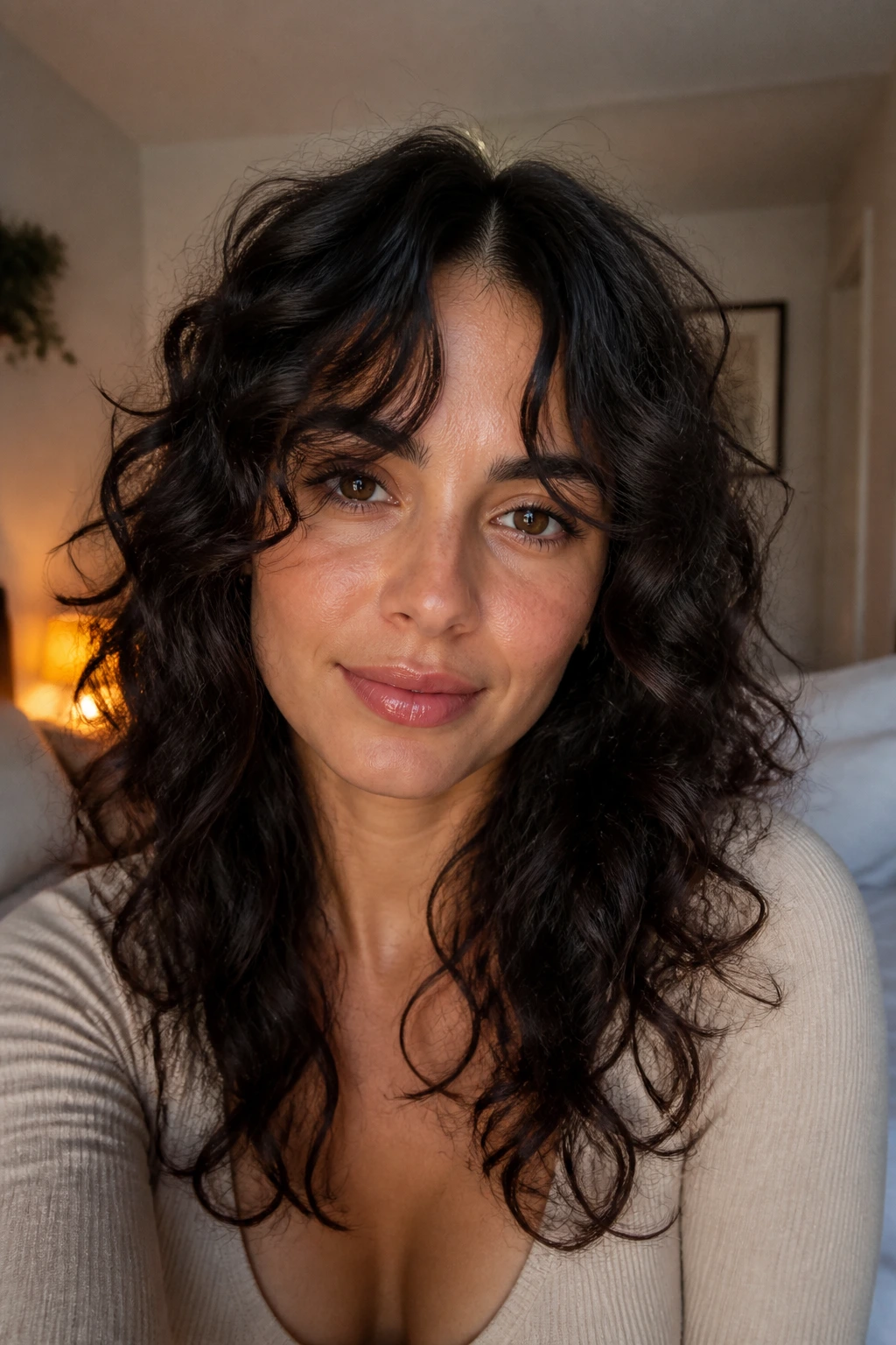Close-up portrait of a real woman with long split bangs and a center opening, soft curls framing the face.