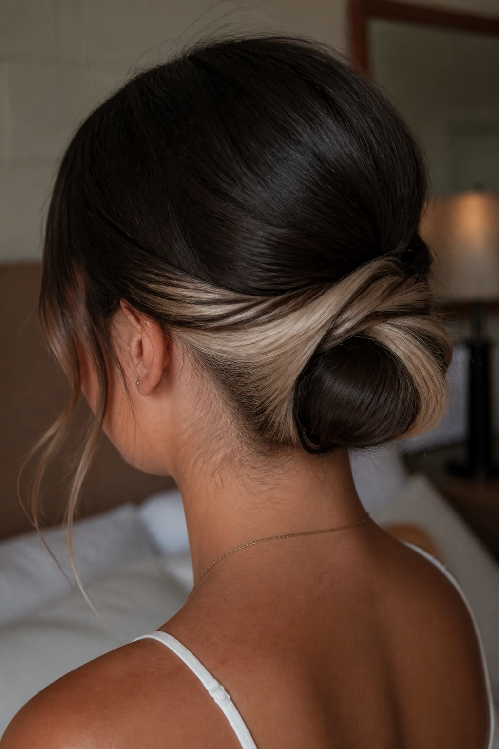 Close-up of a real woman with a low bun revealing a blonde underlayer