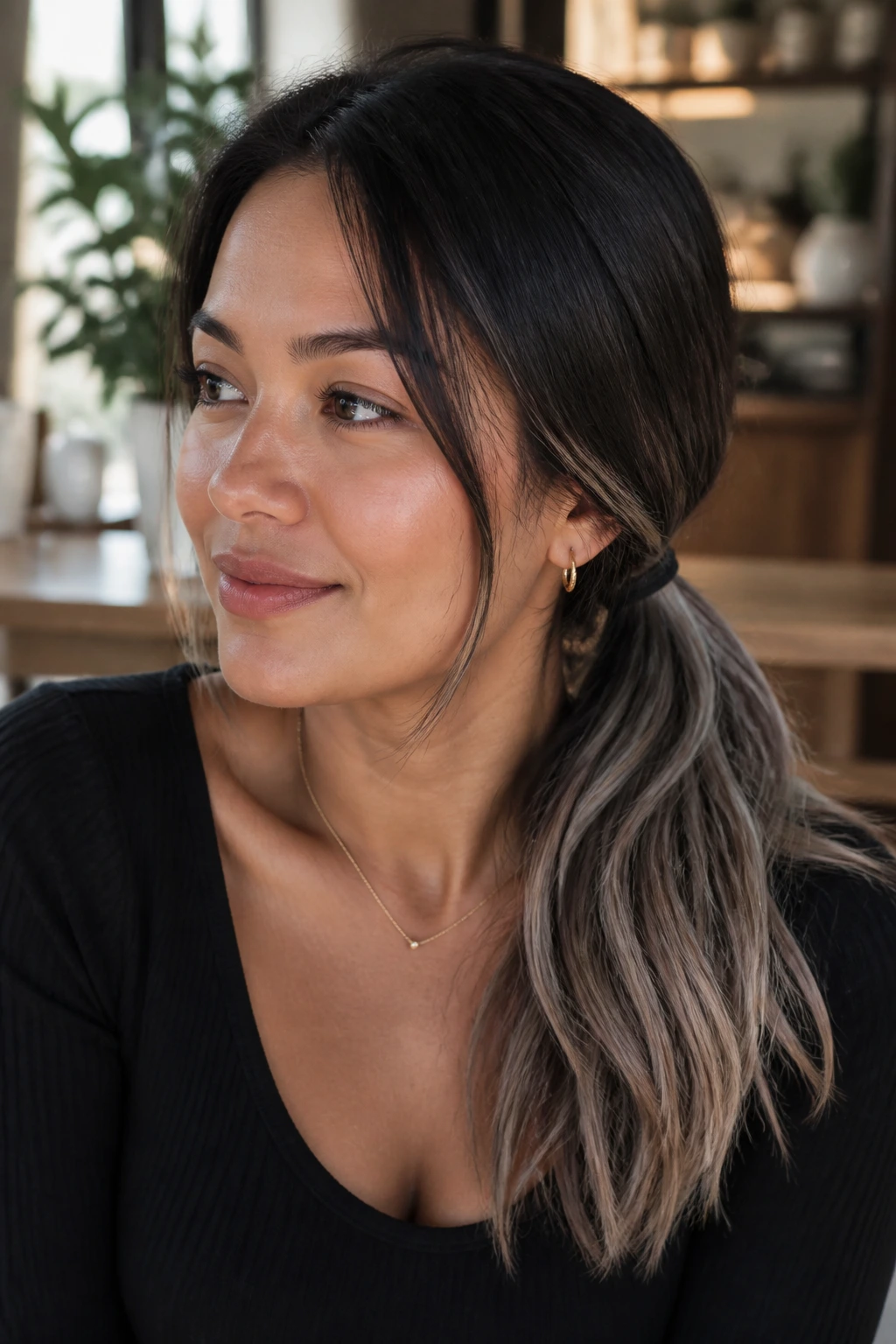 Close up of real woman with low ponytail and diffused grey ends on tan skin