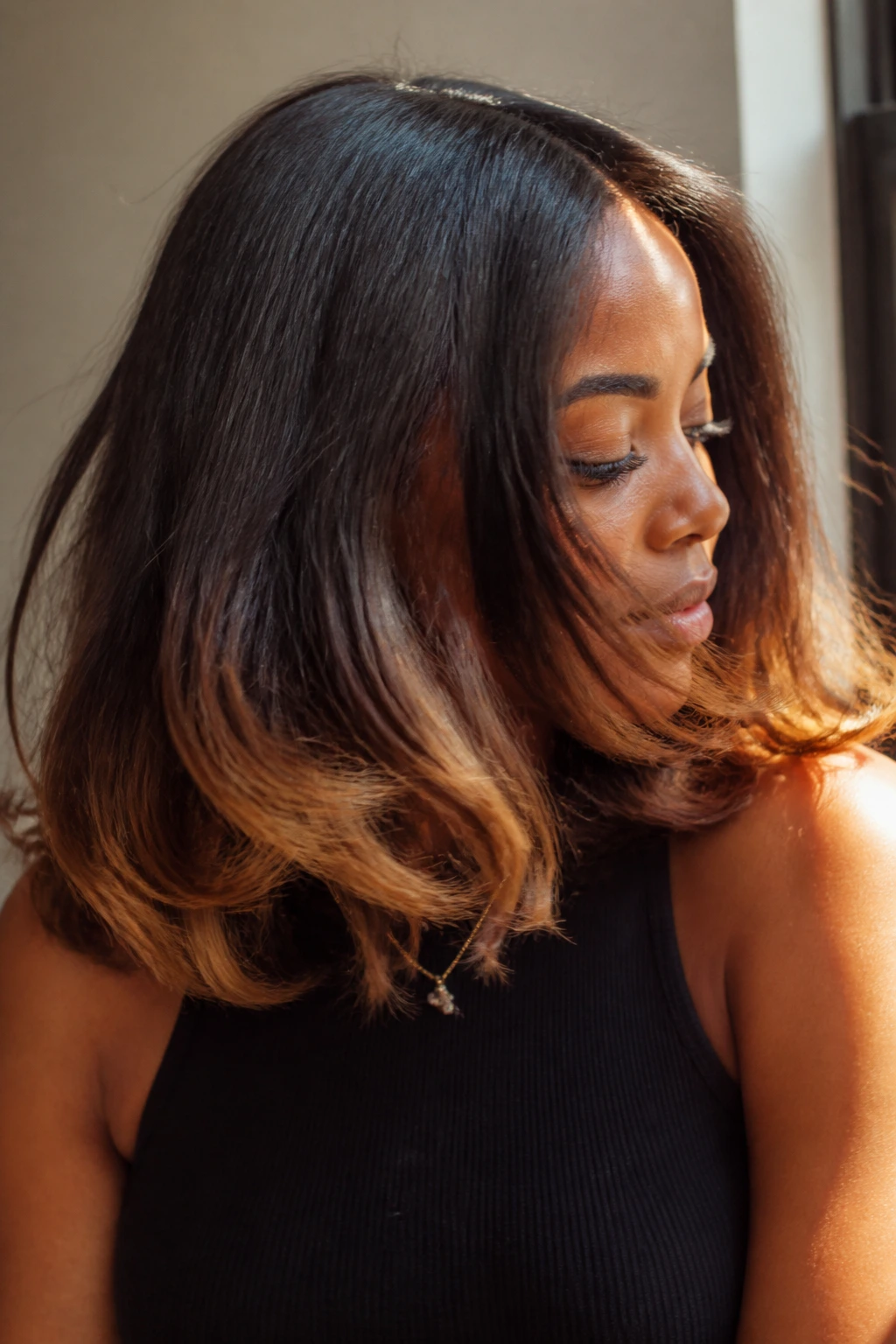 Real person with maple syrup ends on shoulder-length hair catching warm light