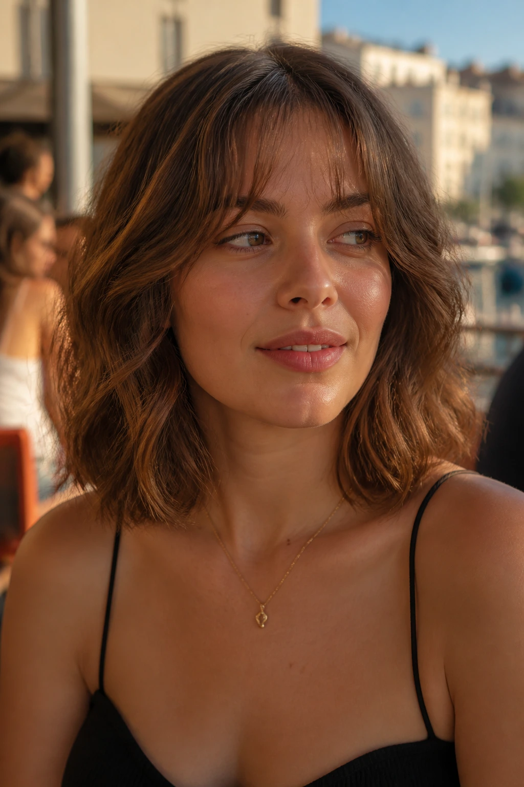 Real woman with micro curtain bangs and collarbone-length lob in golden-hour outdoor setting.