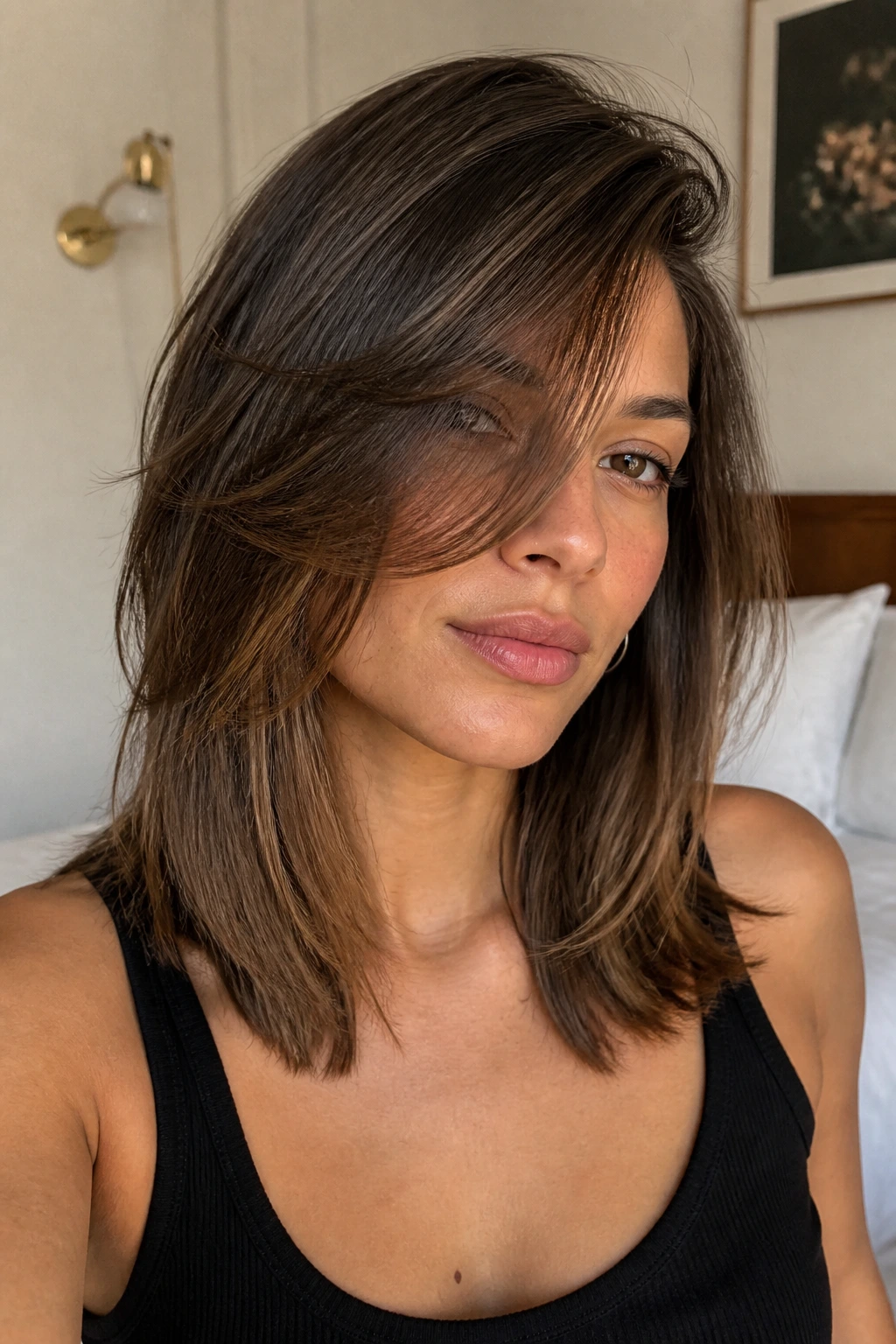 Close-up of a real person with mid-length hair and long front layers swept across the face.
