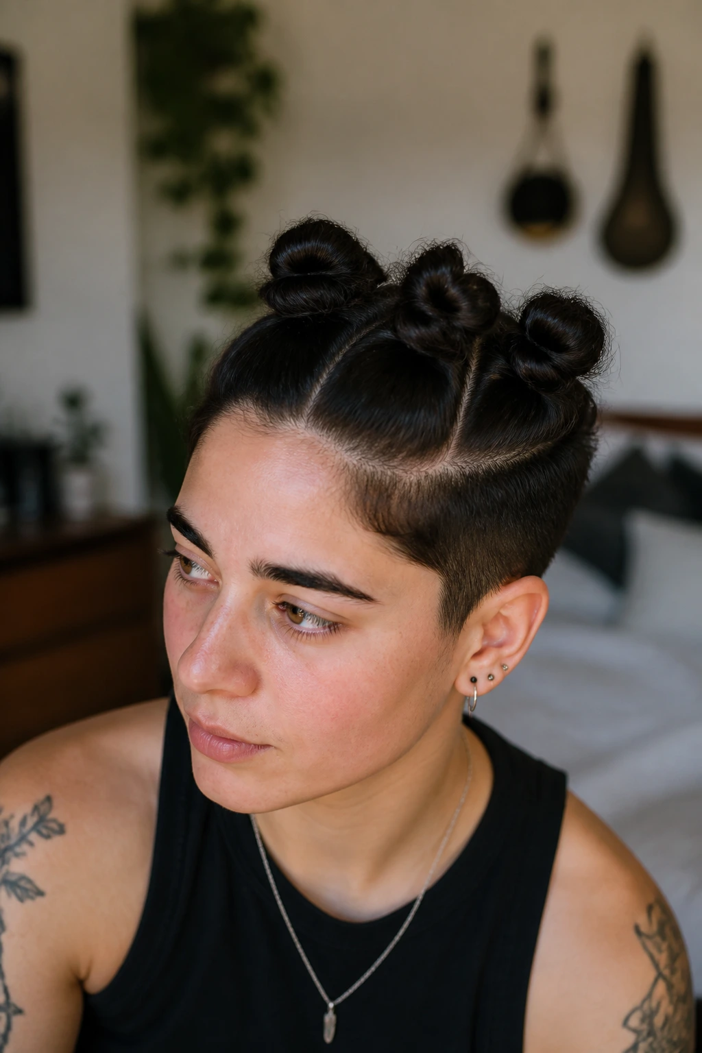 Close-up of a real person with mini buns along the crown of the head.