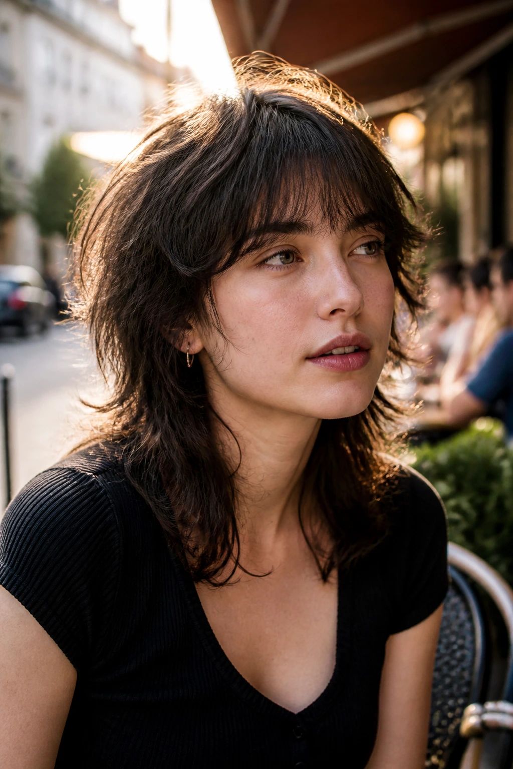 Close-up portrait of a woman with a soft-edged modern wolf cut in golden hour light